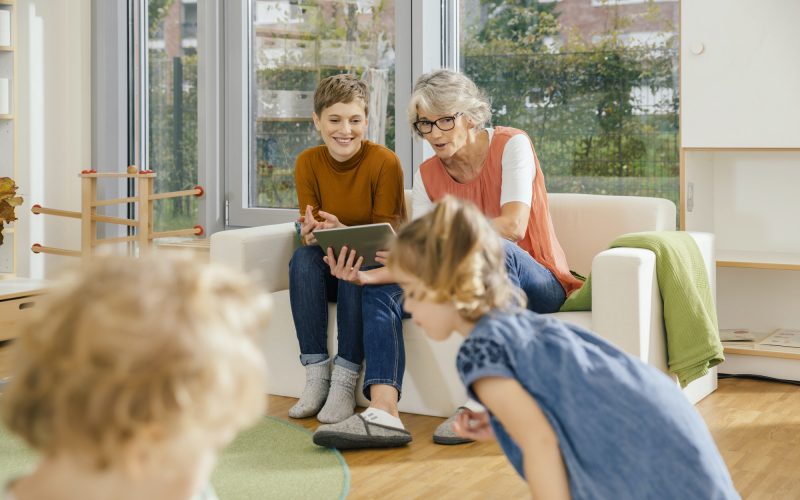 pre-school-teachers-with-tablet-looking-at-children-in-kindergarten.jpg